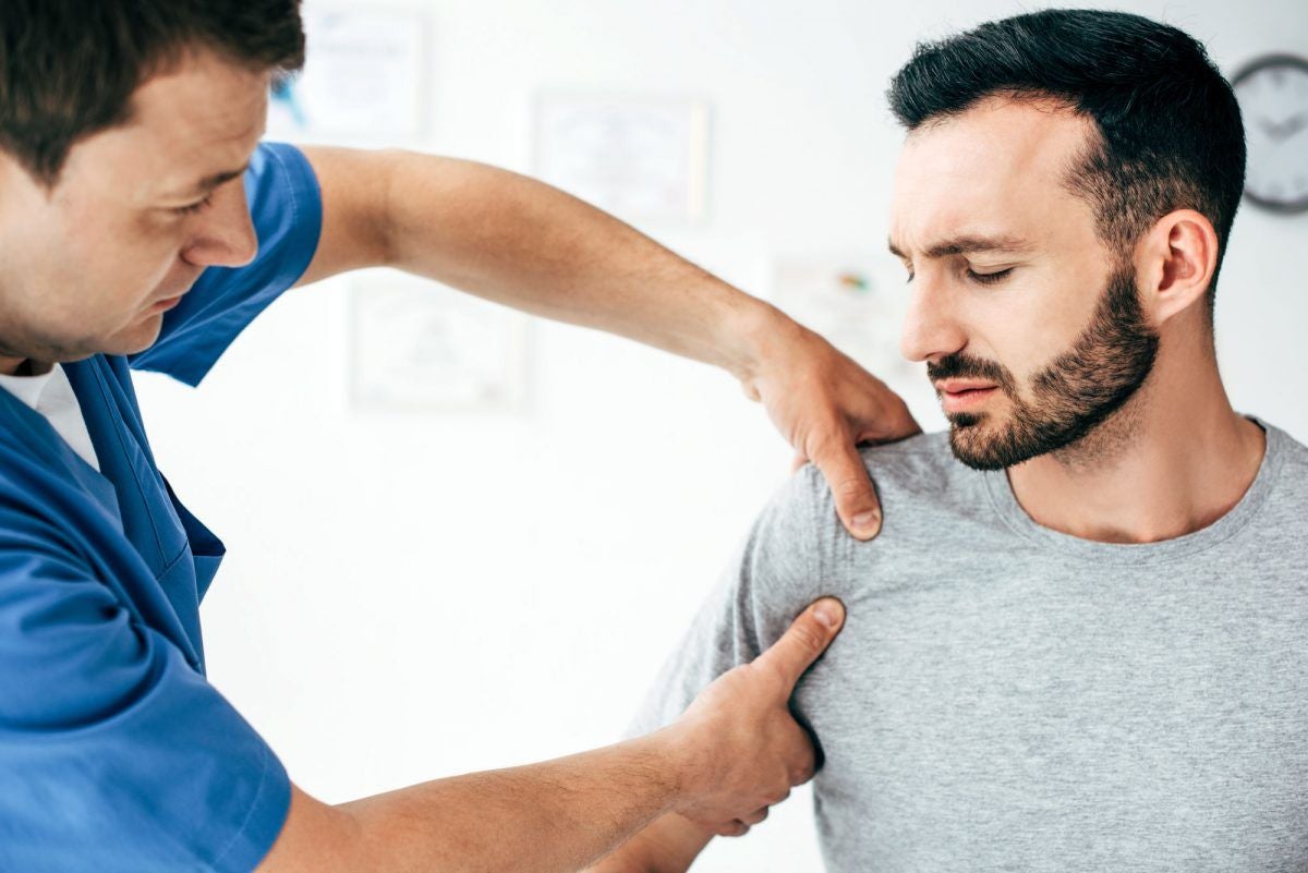 image of a doctor checking a man's shoulder